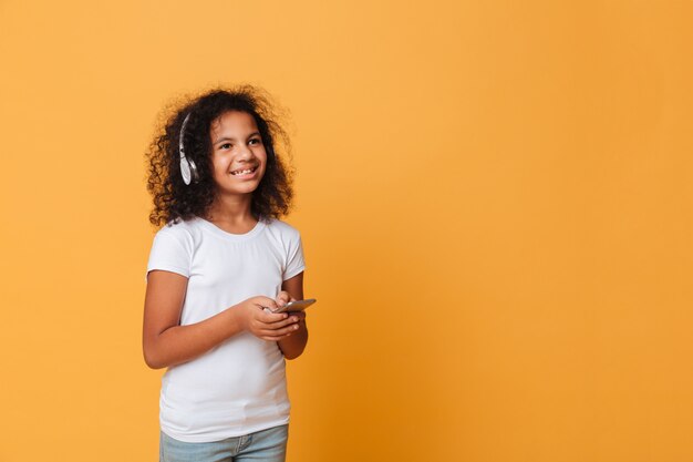 Ritratto di una bambina africana felice che ascolta la musica