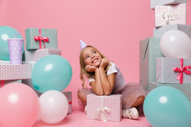 Ritratto di una bambina allegra in un cappello di compleanno