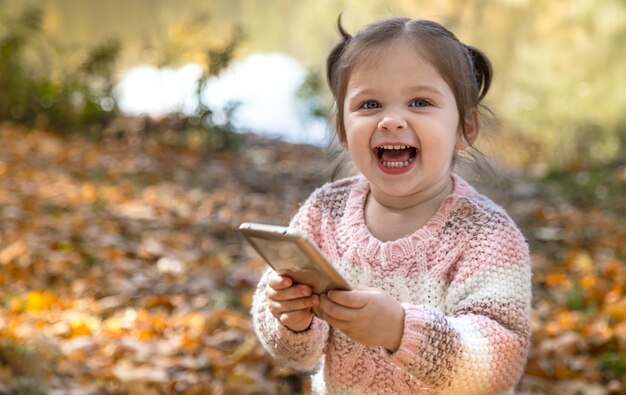 Ritratto di una bambina nella foresta di autunno.