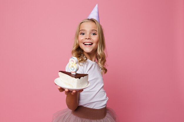 Ritratto di una bambina sorridente in un cappello di compleanno