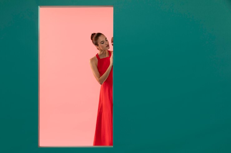 Foto gratuito ritratto di una bella donna che posa in un vestito rosso fluido con spazio di copia