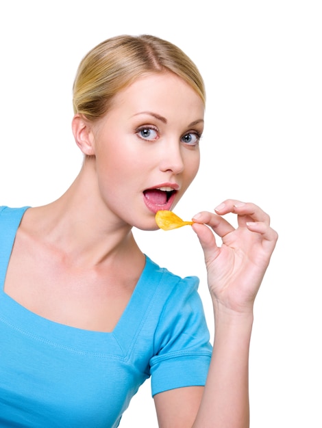 Ritratto di una bella donna felice con un chip vicino alla bocca. Copia spazio