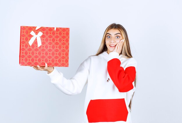 Ritratto di una bella modella in piedi che mostra una borsa regalo