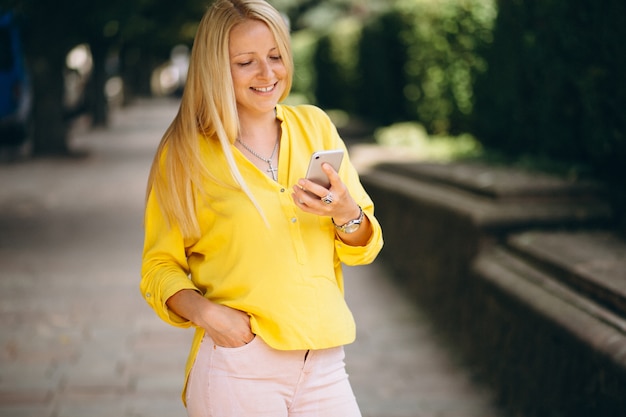 Ritratto di una bella ragazza bionda parlando al telefono