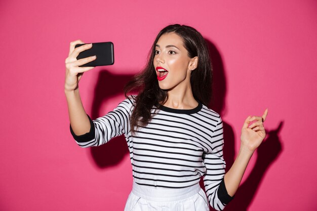 Ritratto di una bella ragazza che prende un selfie