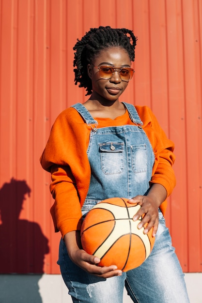 Ritratto di una bella ragazza in posa con la palla da basket