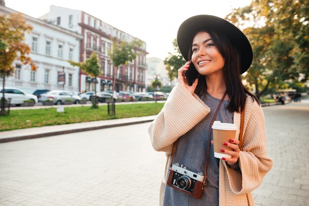 Ritratto di una donna alla moda allegra che tiene tazza di caffè