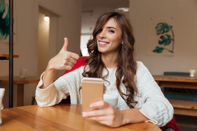 Ritratto di una donna allegra che tiene telefono cellulare