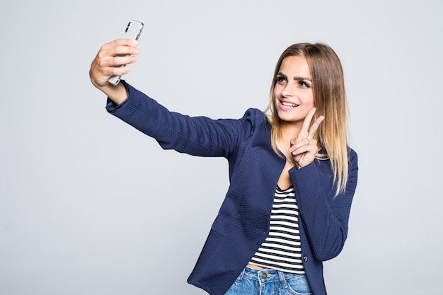 Ritratto di una donna carina sorridente che fa selfie foto sullo smartphone isolato