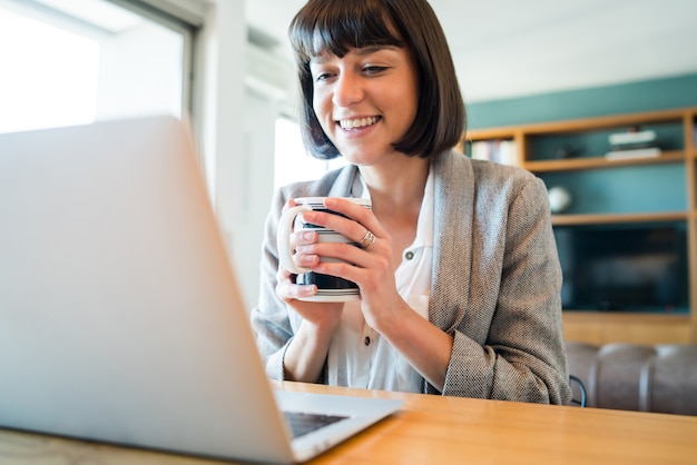 Ritratto di una donna che lavora a casa e fa una videochiamata con il laptop