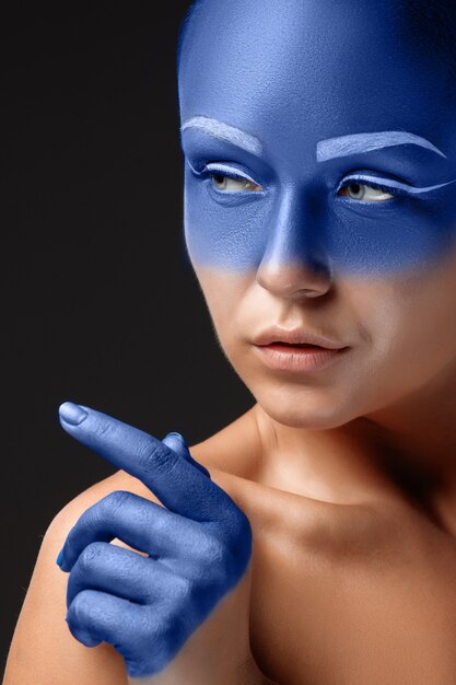 Ritratto di una donna che posa ricoperta di vernice blu