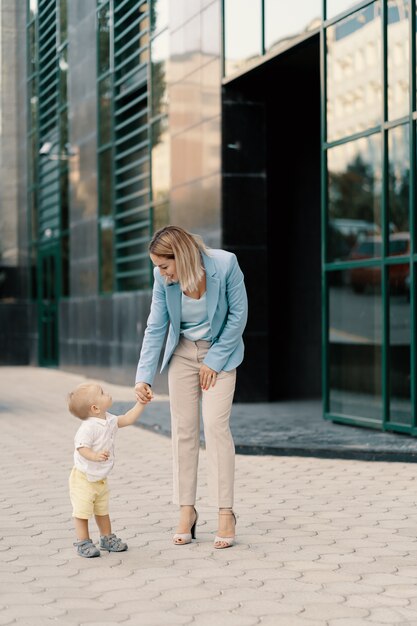Ritratto di una donna d'affari di successo in abito blu con bambino