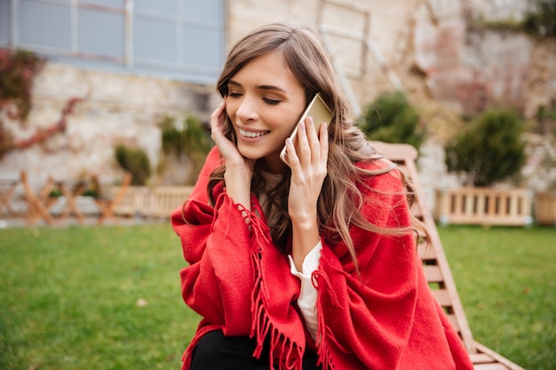 Ritratto di una donna felice che parla sul telefono cellulare