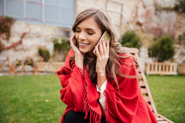 Ritratto di una donna felice che parla sul telefono cellulare
