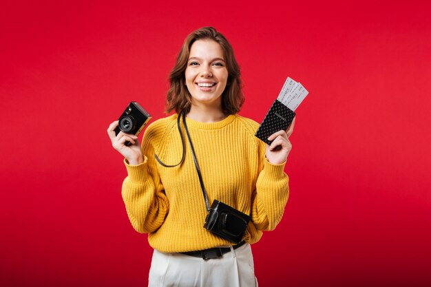 Ritratto di una donna felice che tiene macchina fotografica d'epoca