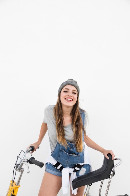 Ritratto di una donna felice con la bicicletta che guarda l&#39;obbiettivo