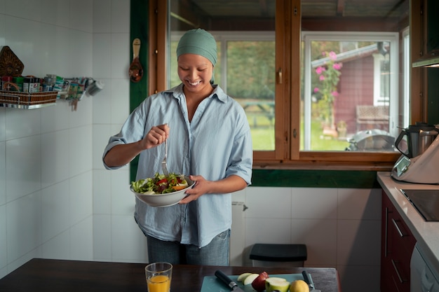 Ritratto di una donna malata di cancro che mangia l'insalata a casa