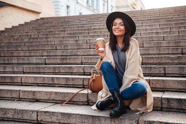 Ritratto di una donna piuttosto eccitata tenendo la tazza di caffè