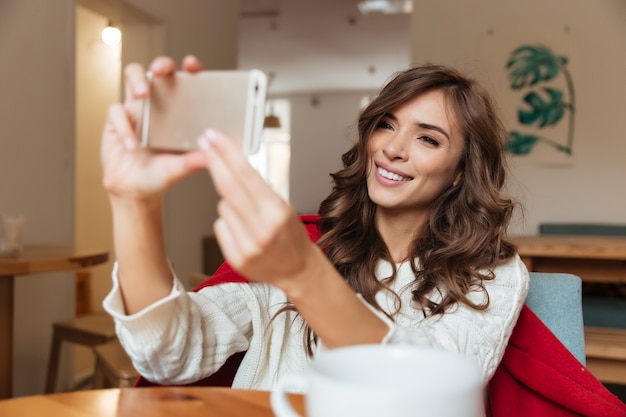 Ritratto di una donna sorridente che prende un selfie