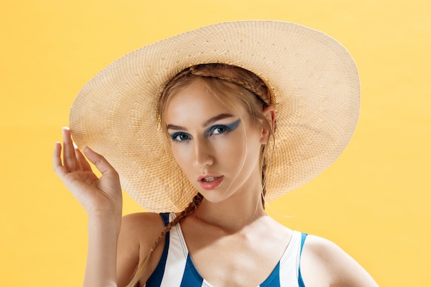 Ritratto di una donna su una spiaggia che indossa un cappello