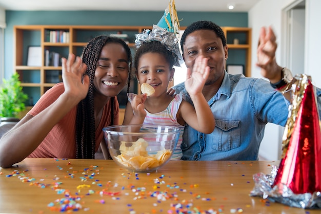 Ritratto di una famiglia che festeggia il compleanno online durante una videochiamata restando a casa