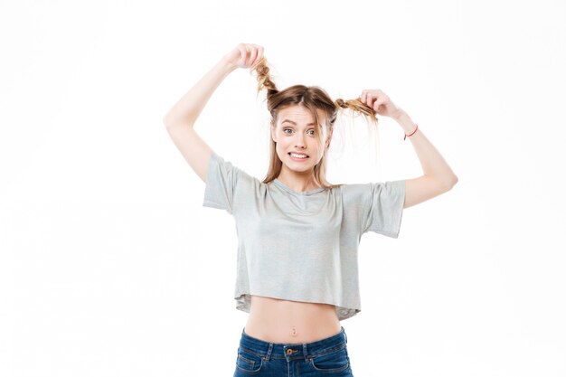 Ritratto di una giovane donna che tira capelli e che guarda l'obbiettivo