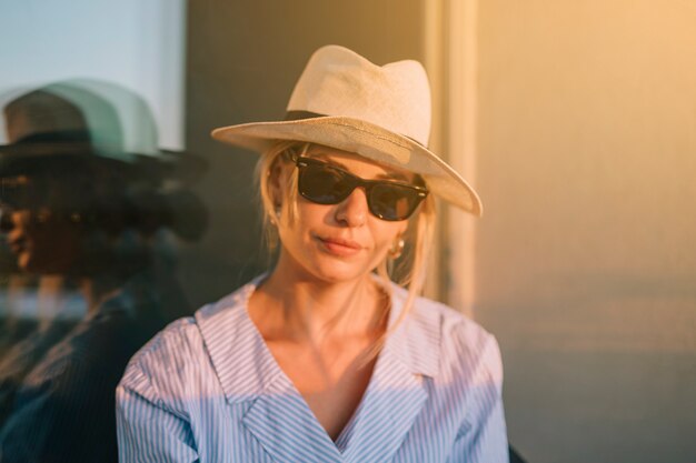 Ritratto di una giovane donna con cappello e occhiali da sole
