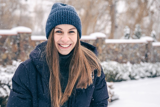 Ritratto di una giovane donna con cappello e piumino in inverno