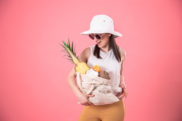 Ritratto di una giovane donna elegante con un sacchetto di frutta ecologica