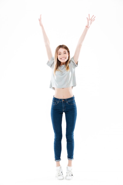Ritratto di una giovane donna emozionante felice che sta e che celebra successo
