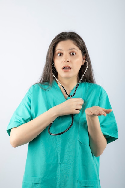 Ritratto di una giovane donna medico con stetoscopio in uniforme.