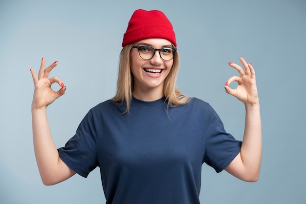 Ritratto di una giovane donna sorridente e mostrando il segno giusto