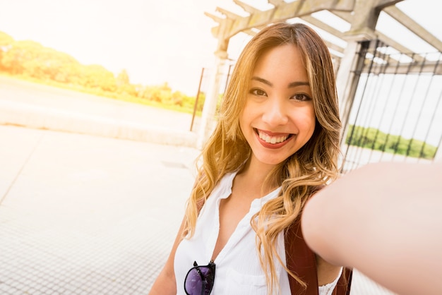 Ritratto di una giovane donna sorridente prendendo autoritratto