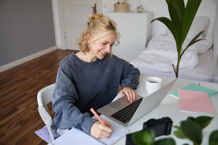 Foto gratuito ritratto di una giovane donna sorridente, una studentessa che fa un corso di apprendimento a distanza usando un portatile che studia
