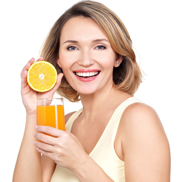Ritratto di una giovane e bella donna con un bicchiere di succo di frutta e arancia isolato su bianco.