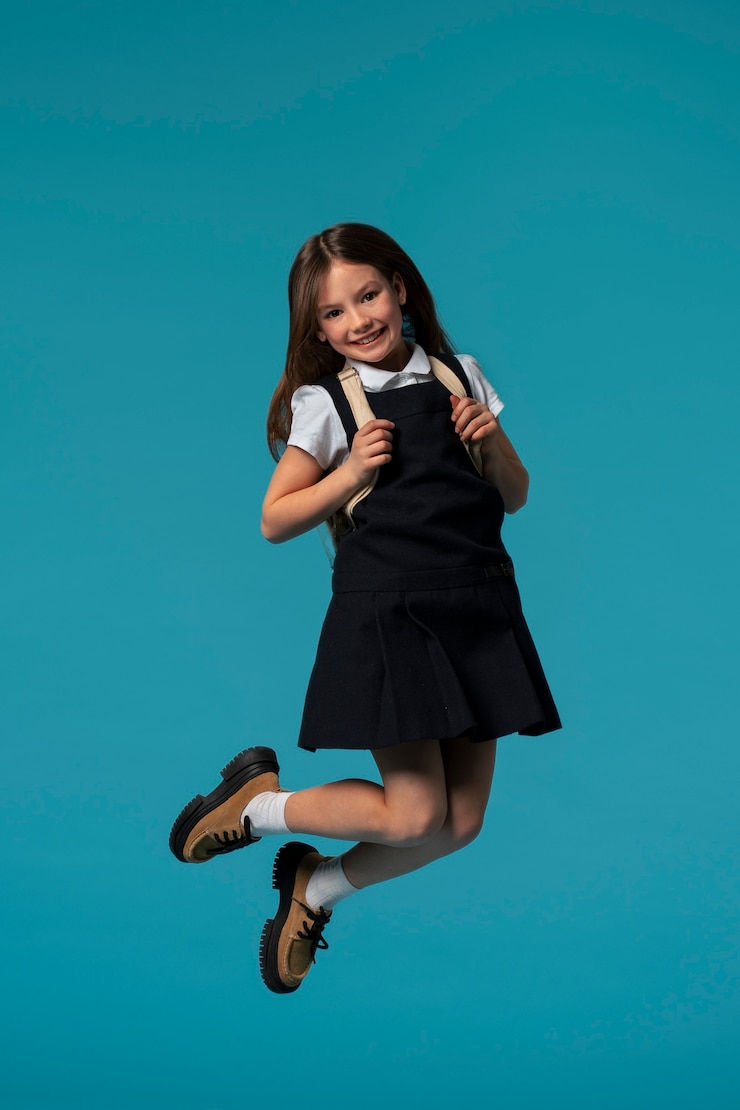 Foto gratuito ritratto di una giovane studentessa in uniforme scolastica che salta a mezz'aria
