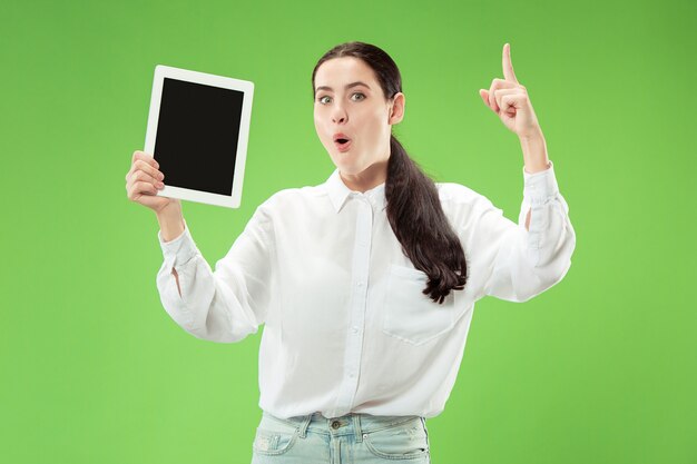 Ritratto di una ragazza casuale sicura che mostra lo schermo in bianco del computer portatile