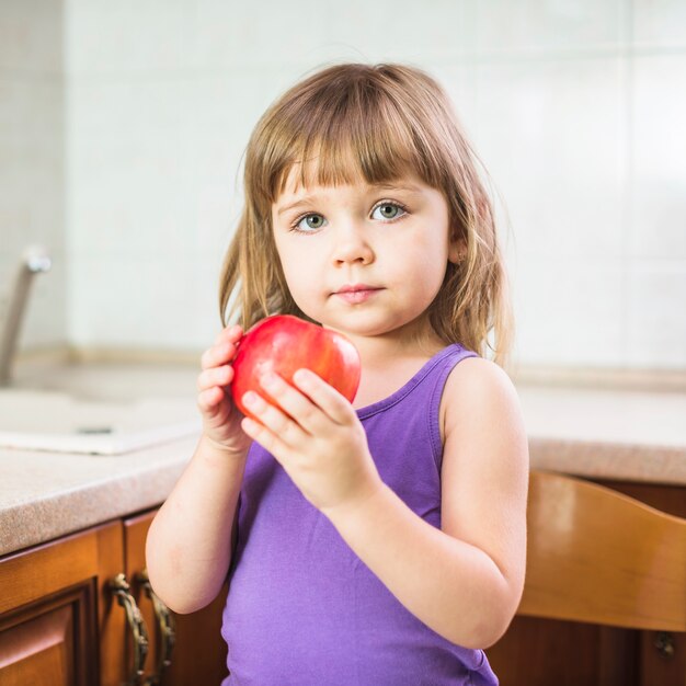 Ritratto di una ragazza che tiene mela rossa fresca