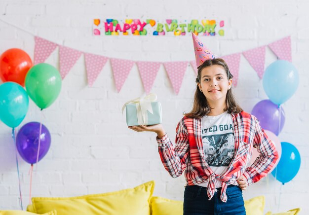 Ritratto di una ragazza con regalo di compleanno guardando la fotocamera