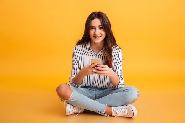 Ritratto di una ragazza sorridente che tiene telefono cellulare