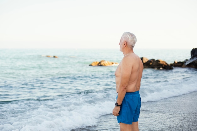 Ritratto di uomo anziano dai capelli grigi in spiaggia