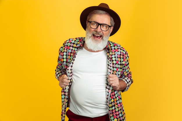 Ritratto di uomo anziano hipster solated su sfondo giallo.