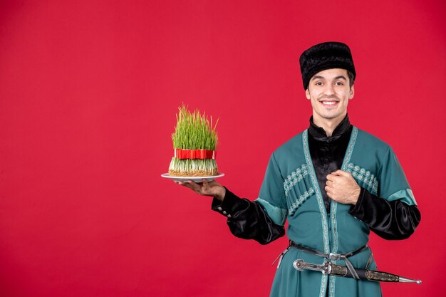 Ritratto di uomo azero in costume tradizionale azienda semeni sorridente studio shot ballerino rosso novruz spring