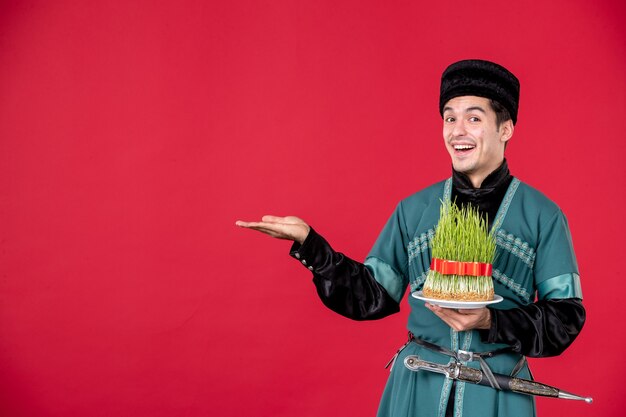 Ritratto di uomo azero in costume tradizionale azienda semeni studio shot concetto rosso novruz primavera