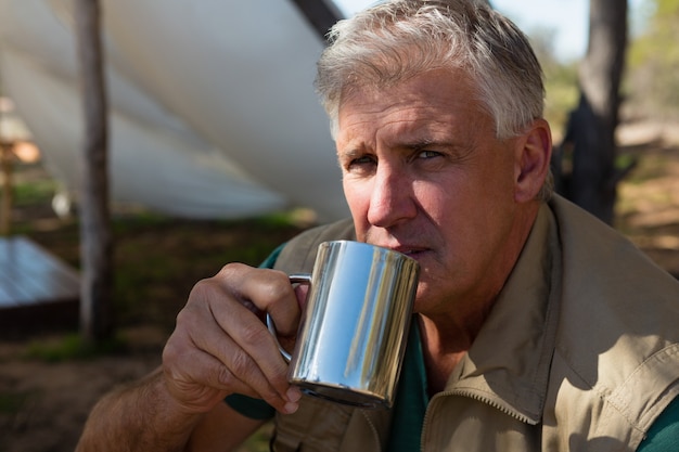 Ritratto di uomo che beve il caffè in campeggio