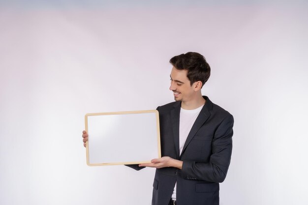 Ritratto di uomo d'affari felice che mostra cartello in bianco su sfondo bianco isolato