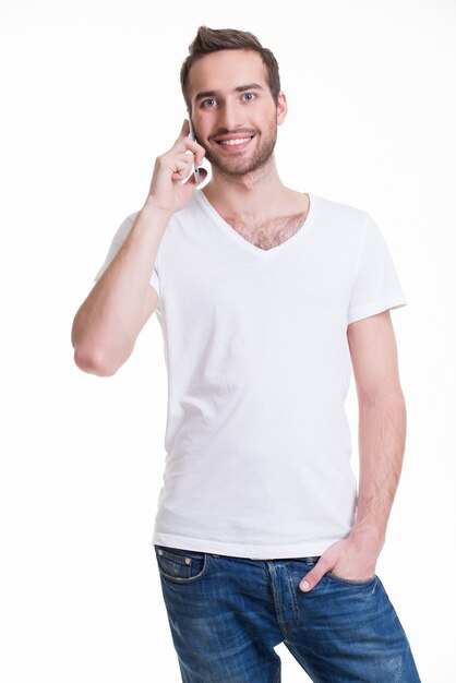 Ritratto di uomo felice che chiama dal cellulare in casuals - isolato su bianco