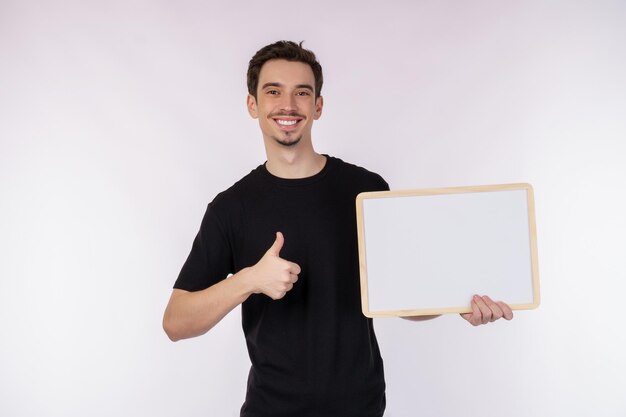 Ritratto di uomo felice che mostra cartello in bianco su sfondo bianco isolato