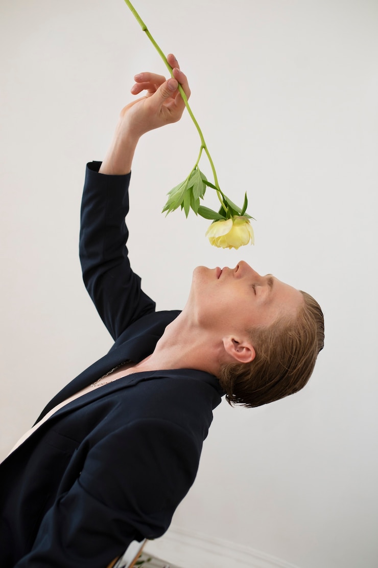Foto gratuito ritratto di uomo in posa con fiore