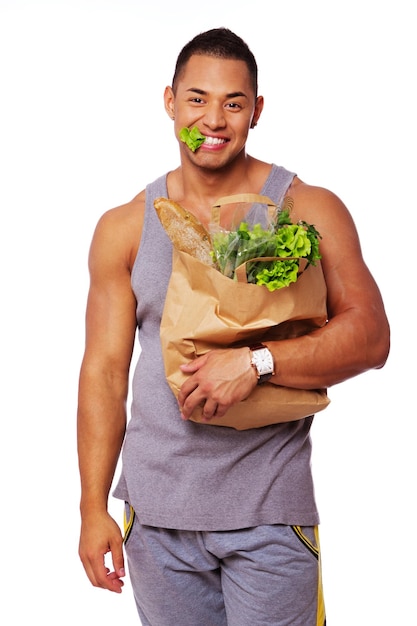 Ritratto di uomo sano in posa in studio con insalata